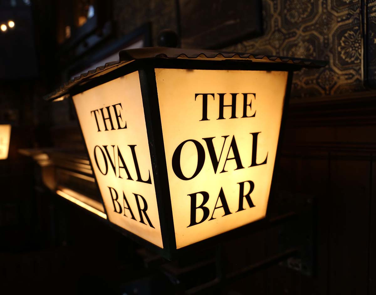 A lamp with the Oval bar logo printed on its shade